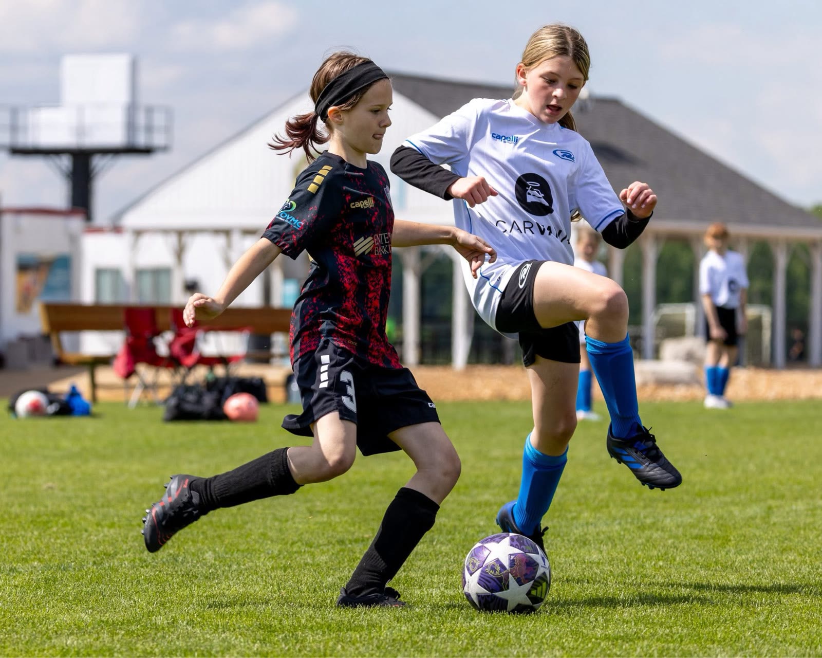 A St. Louis Legends player in a black and red kit challenging an opponent for the ball during a match