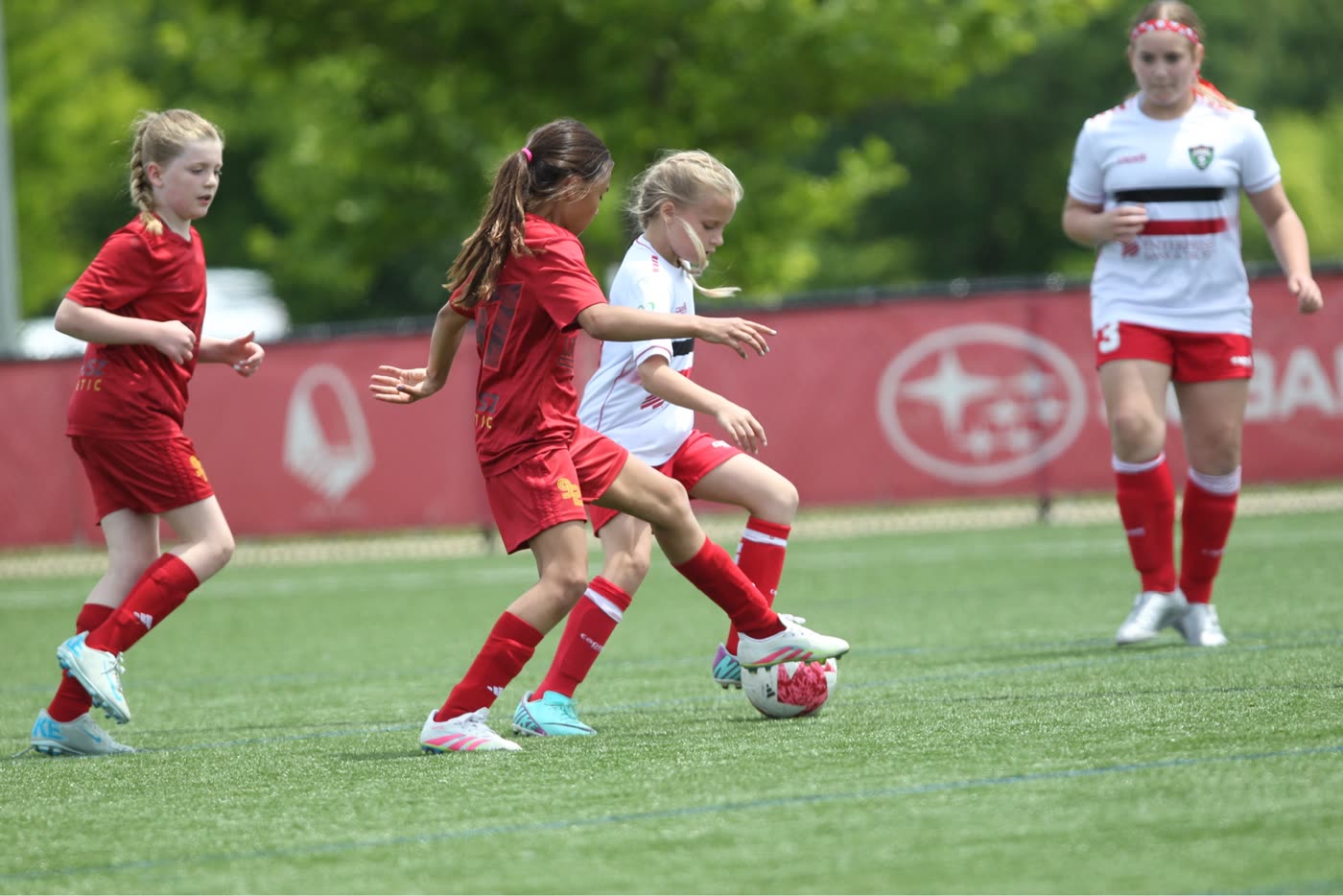 Youth soccer players challenge for the ball during a St. Louis Legends match