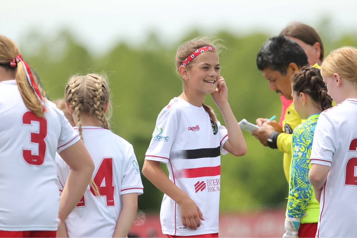 St. Louis Legends players in white kits gather during a match break with coaches nearby
